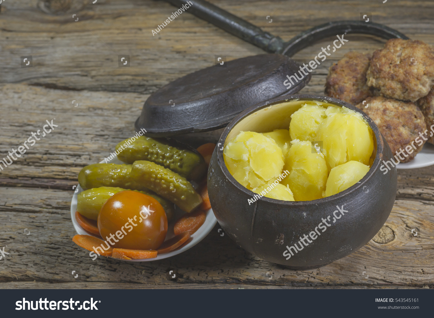 The food in the village. Boiled potatoes with meatballs and pickled cucumbers and tomatoes #543545161