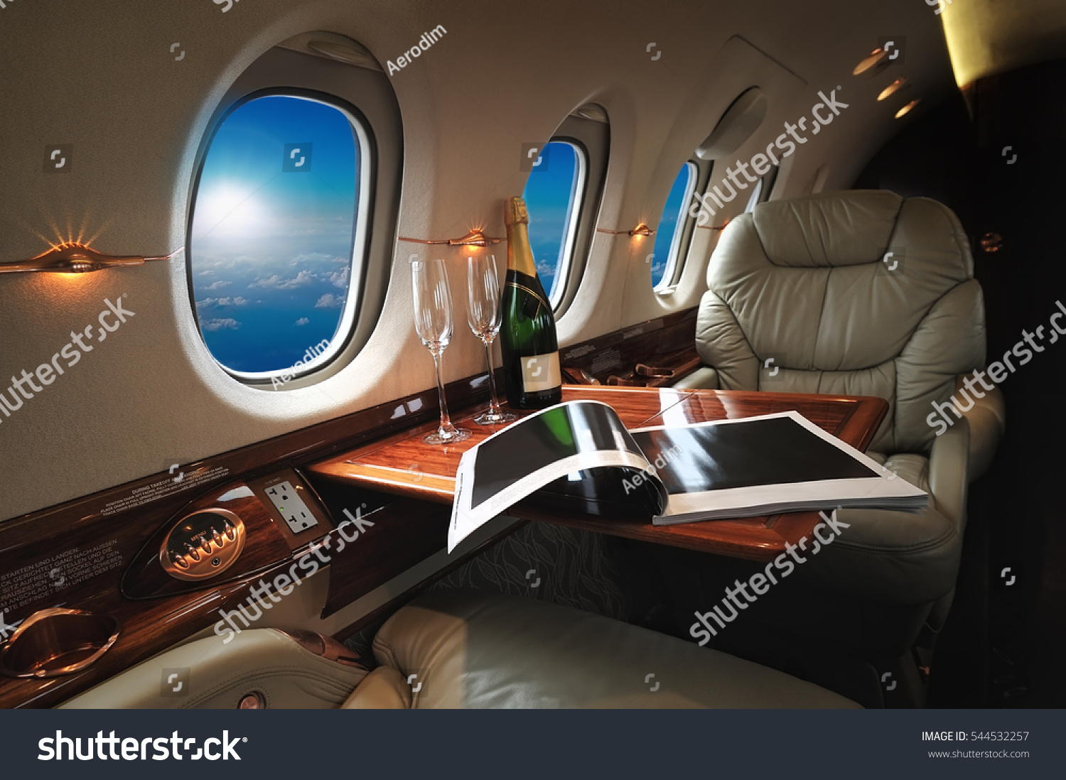 luxury interior in the modern  business jet and sunlight at the window/sky and clouds through the porthole #544532257
