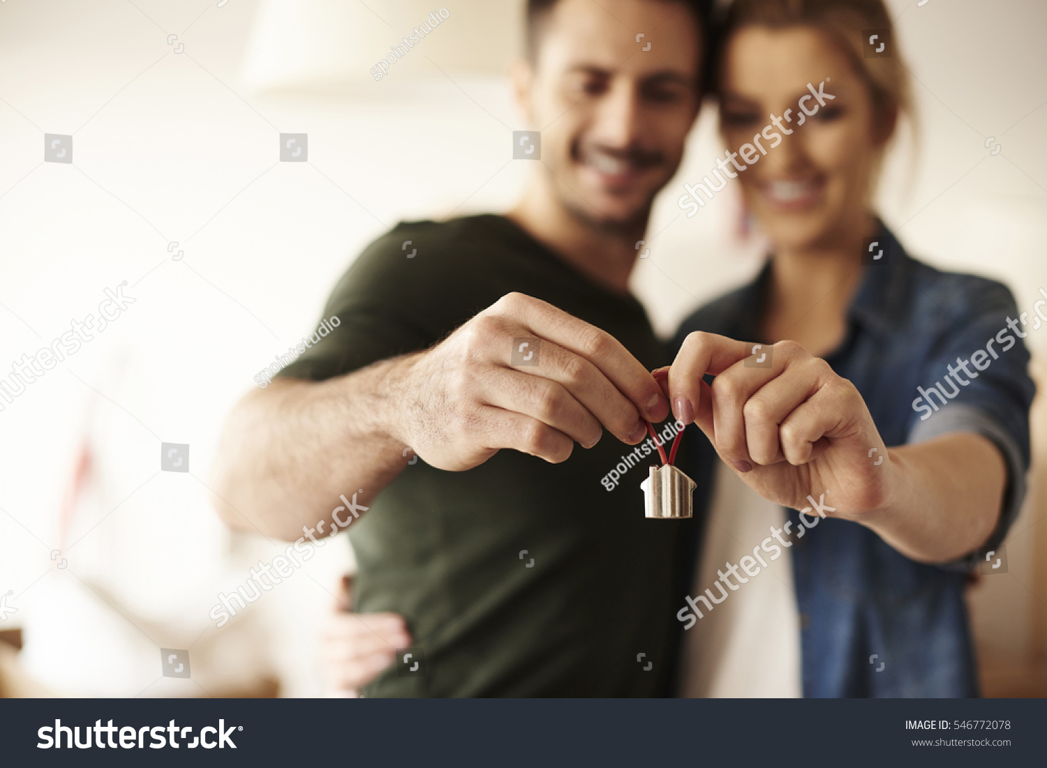 Couple holding key ring to their new house 
 #546772078