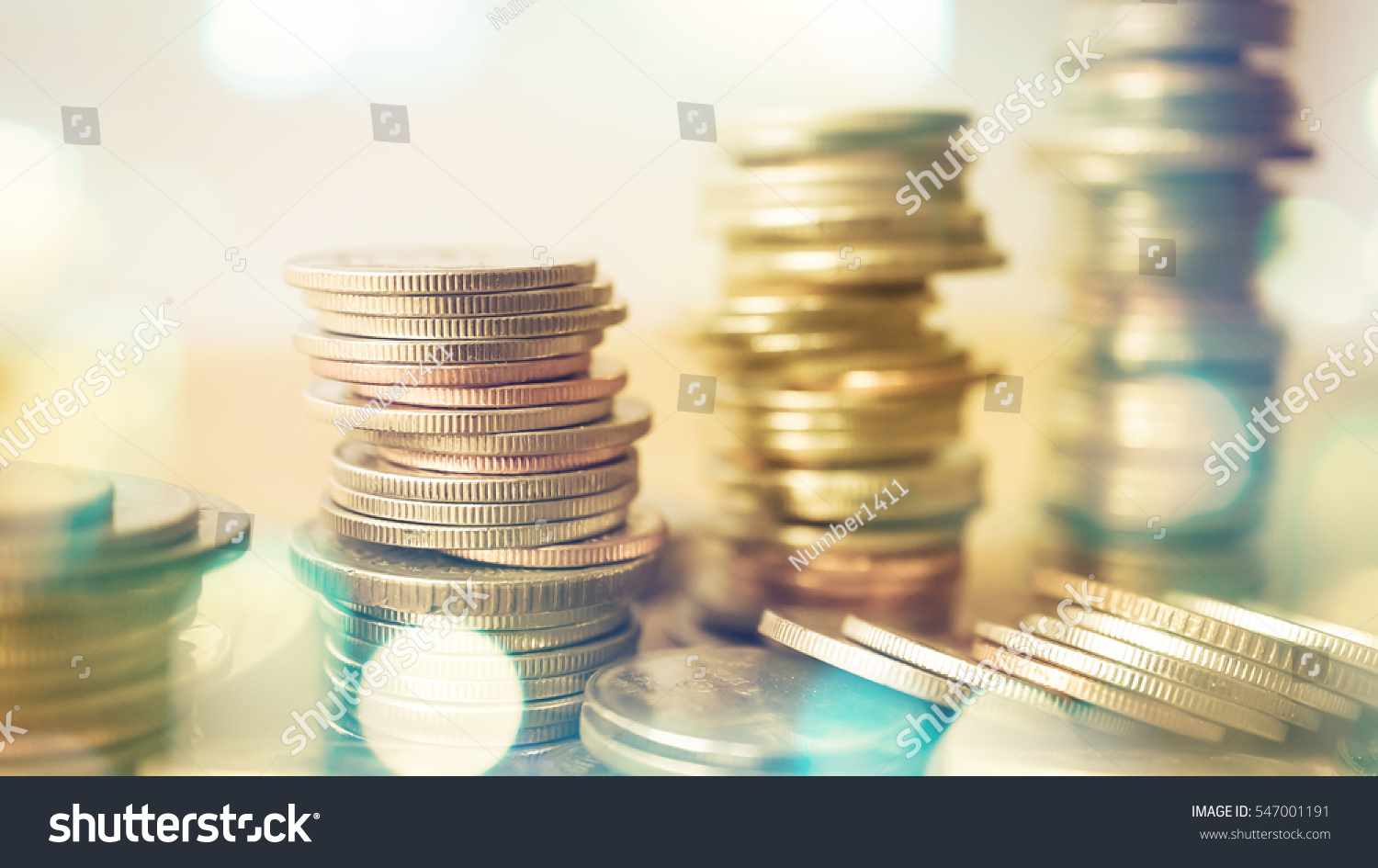 rows of coins and blurred bokeh for finance and banking concept #547001191