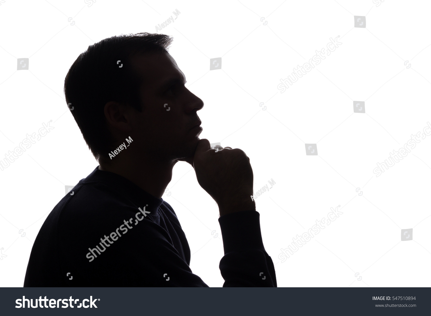 The young man thought his head propped on his hand - silhouette #547510894