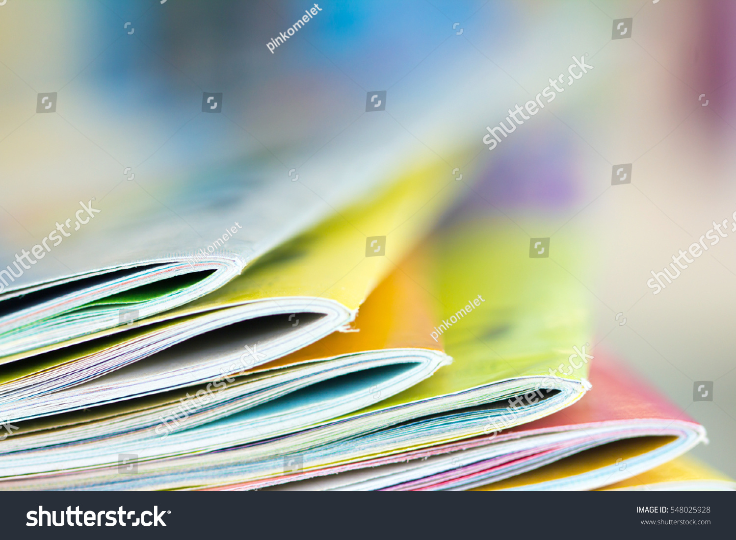 Close up edge of colorful magazine stacking with  blurry bookshelf background for publication and publishing concept , extremely DOF  #548025928