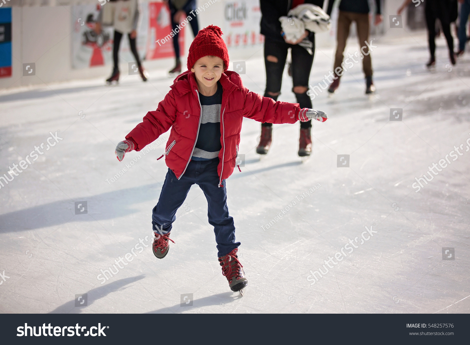 Happy boy with red hat and jacket, skating during the day, having fun #548257576