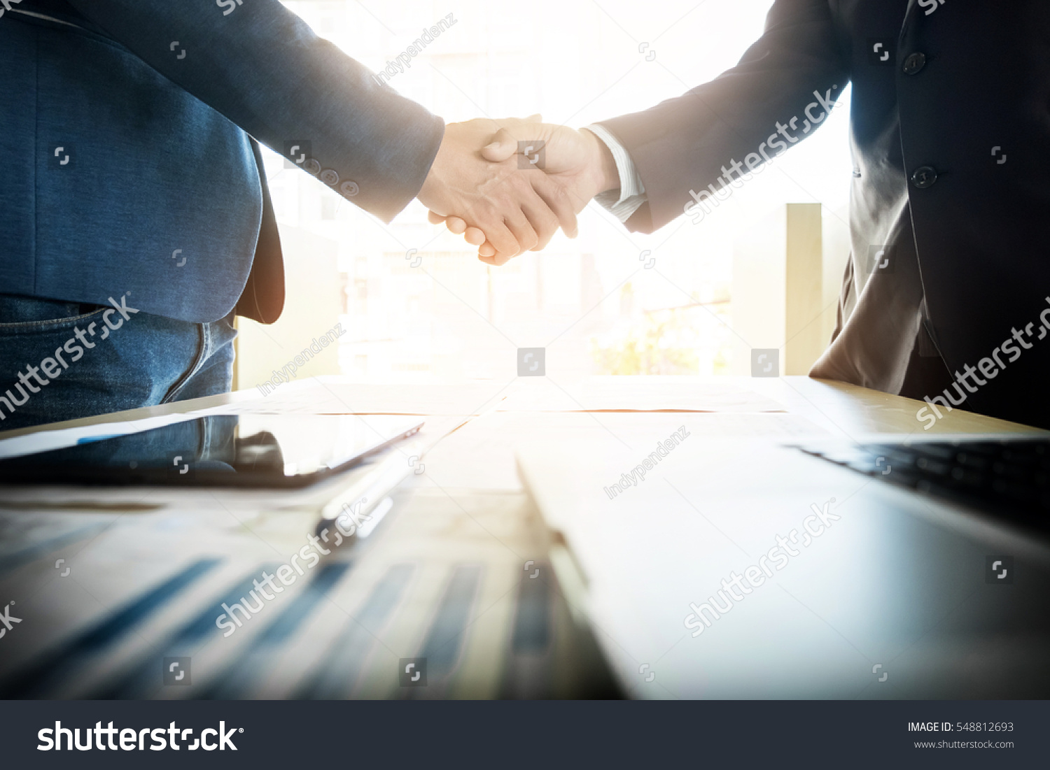 Two confident business man shaking hands during a meeting in the office, success, dealing, greeting and partner concept. #548812693