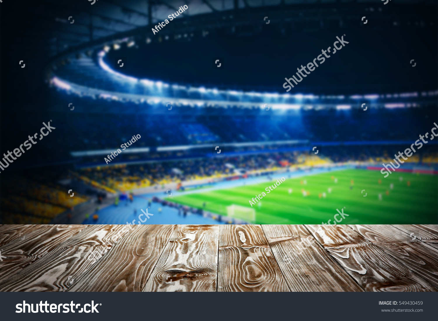 Wooden table against football stadium background #549430459