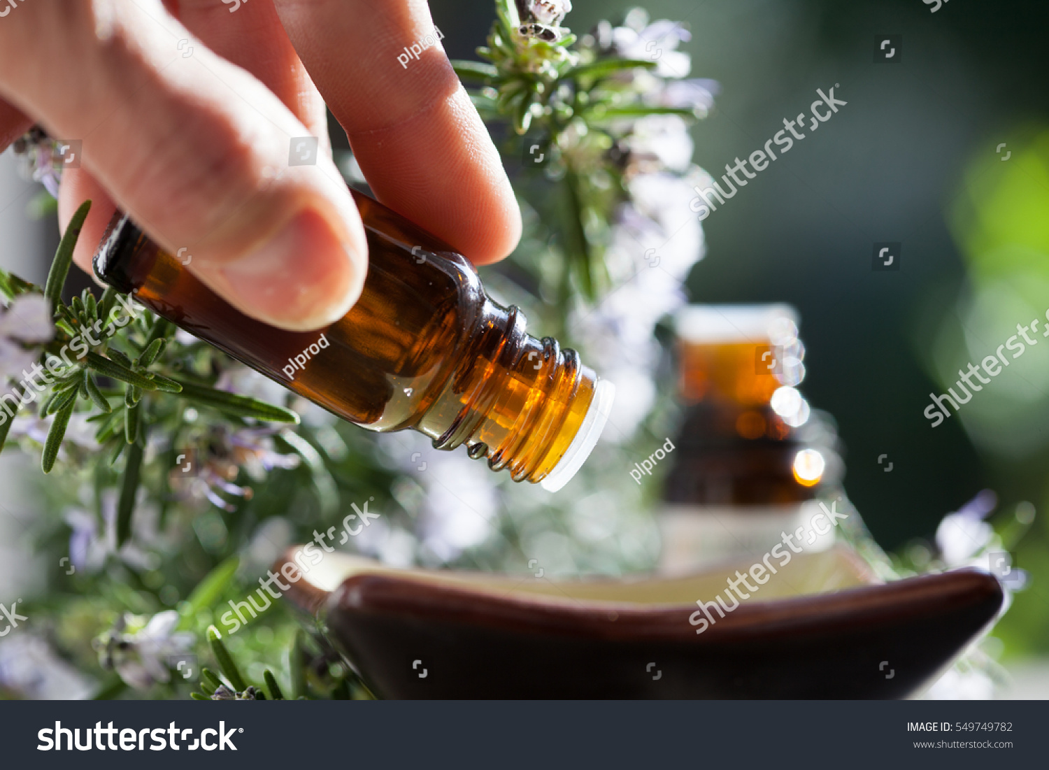 pour rosemary essential oil in a bowl #549749782