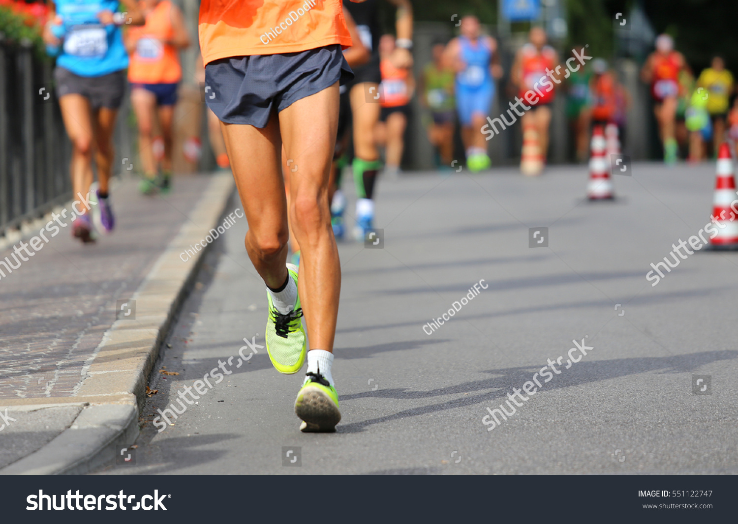 runner during race walking in the city with many athletes from all nations #551122747