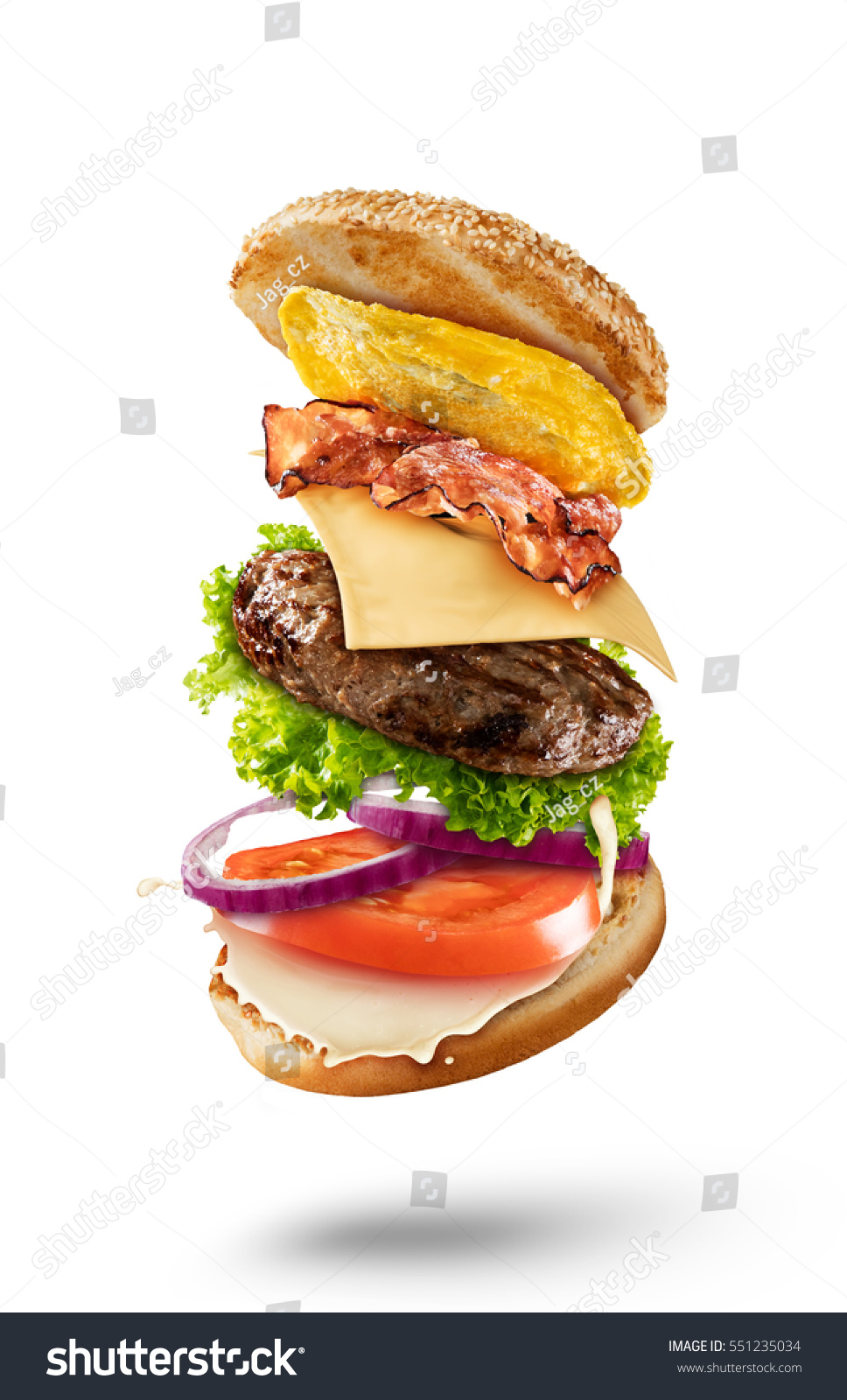 Maxi hamburger with flying ingredients isolated on white background. High resolution image #551235034