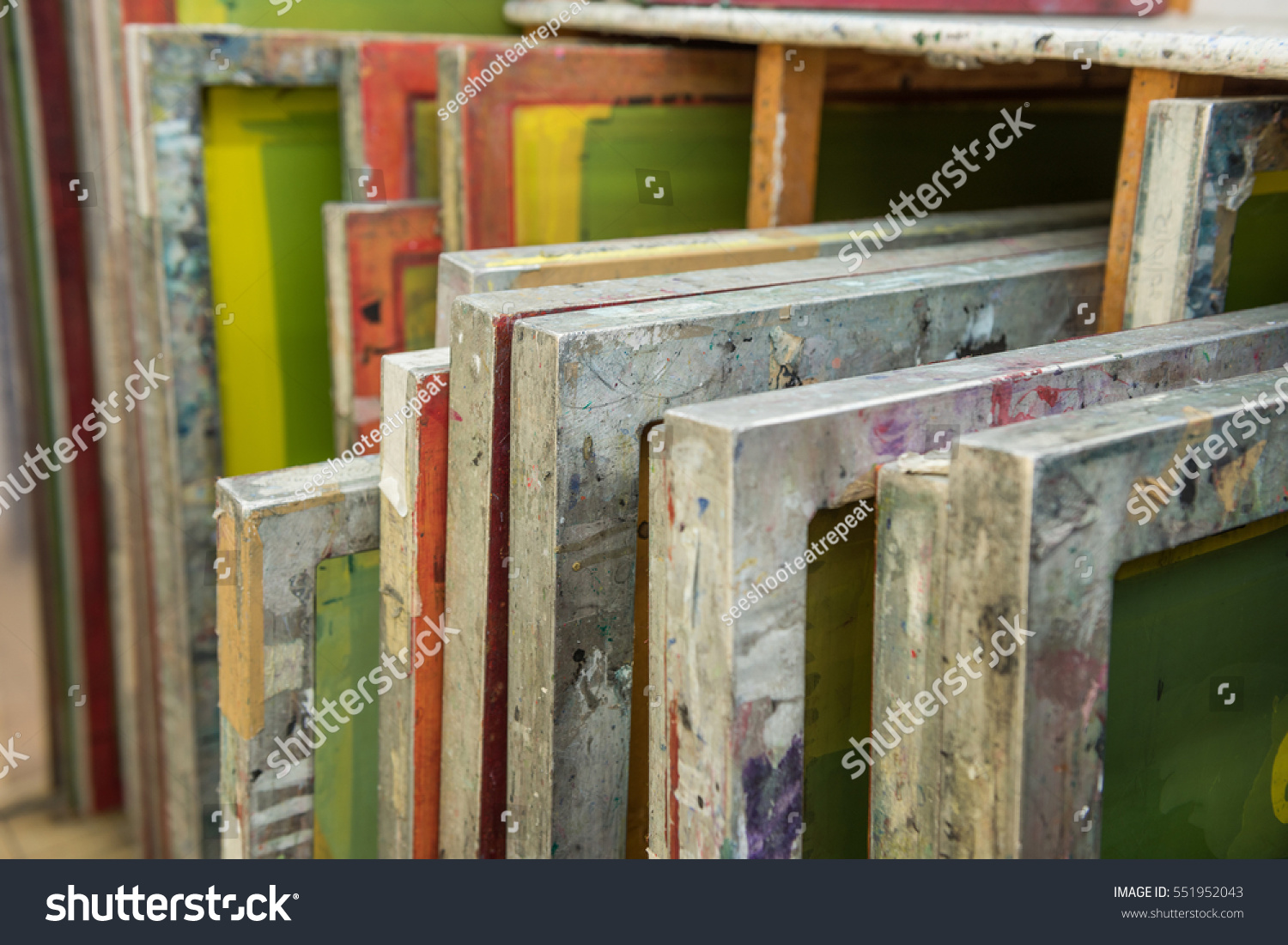 Silk screen printing screens stored in a wooden rack ready for printing. #551952043