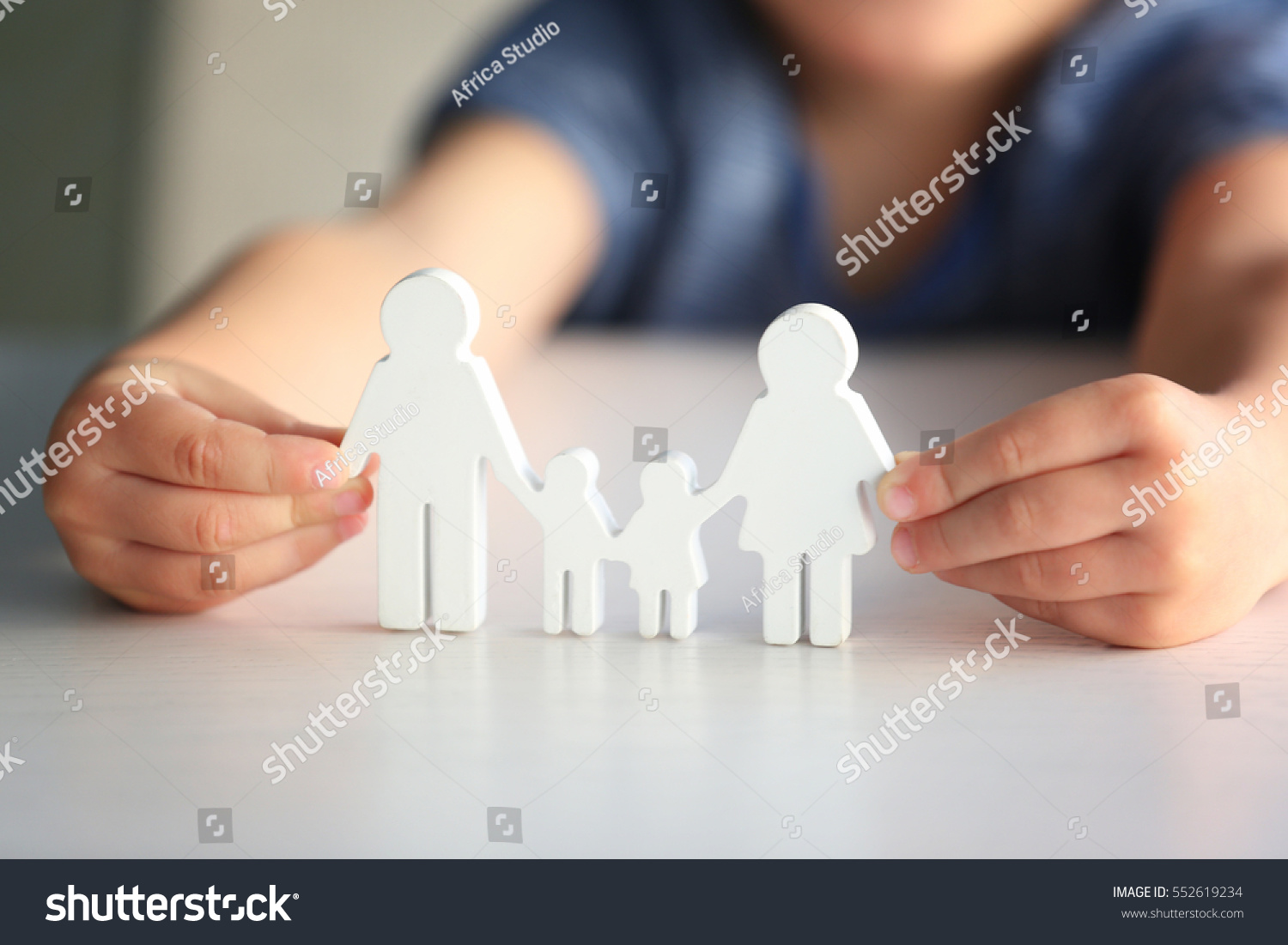 Child holding figure in shape of happy family, closeup. Adoption concept #552619234