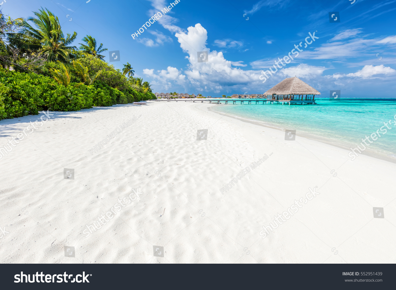 Wide sandy beach on a tropical island in Maldives. Coconut palms and water lodge on Indian Ocean. #552951439