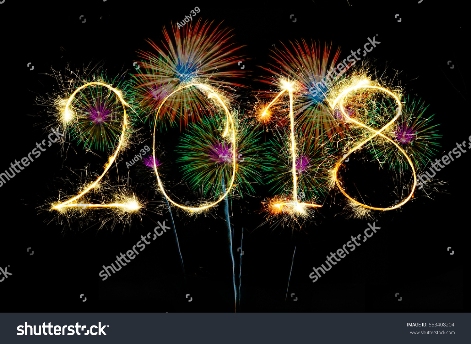 HAPPY NEW YEAR 2018 from colorful sparkle on black background Fireworks light up the sky,New Year celebration fireworks #553408204