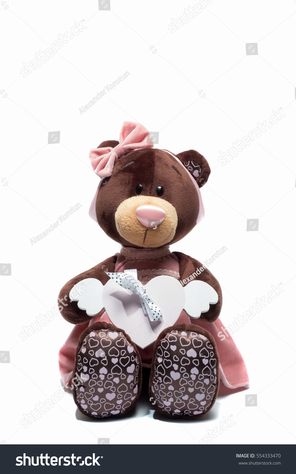 Plush toy bear sitting with heart a pink heart on isolated white background. Valentine day #554333470