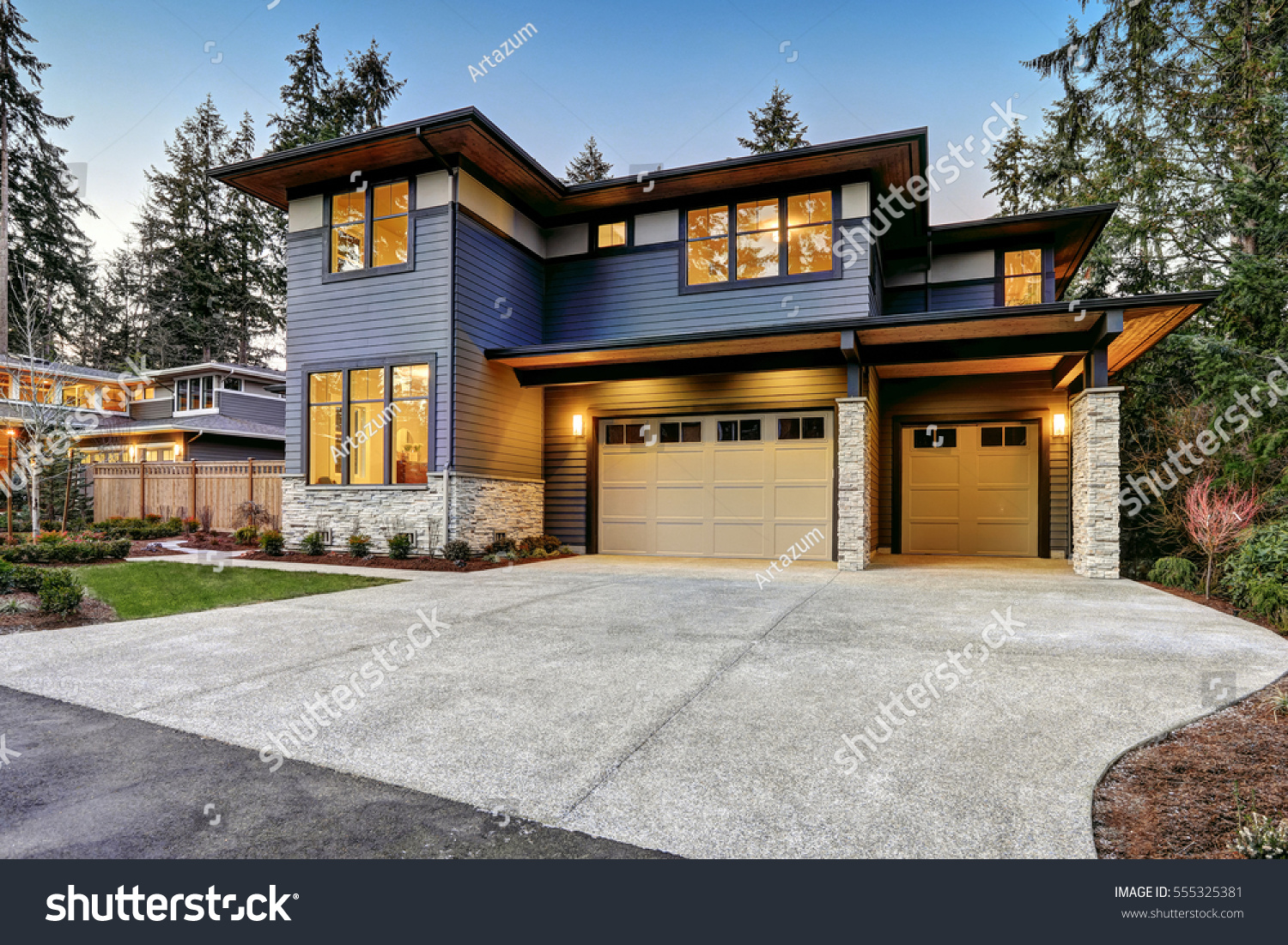 Luxurious new construction home in Bellevue, WA. Modern style home boasts two car garage framed by blue siding and natural stone wall trim. Northwest, USA #555325381