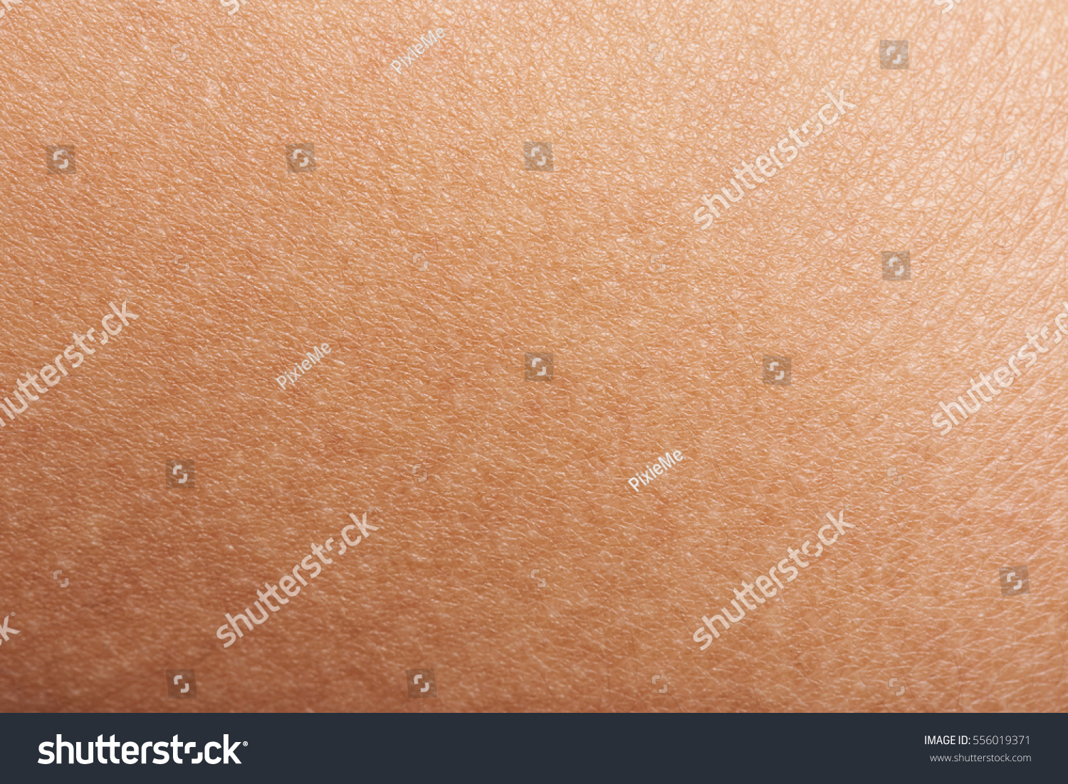 Dark skin of woman hand macro. Human skin texture background #556019371