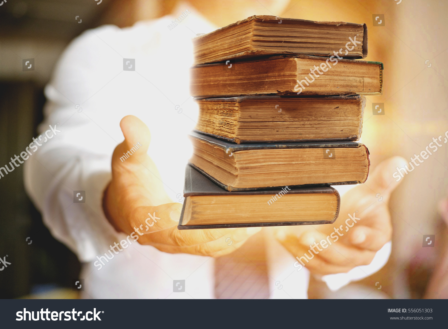 Concept of wisdom, book in man's hands in gesture of giving. #556051303