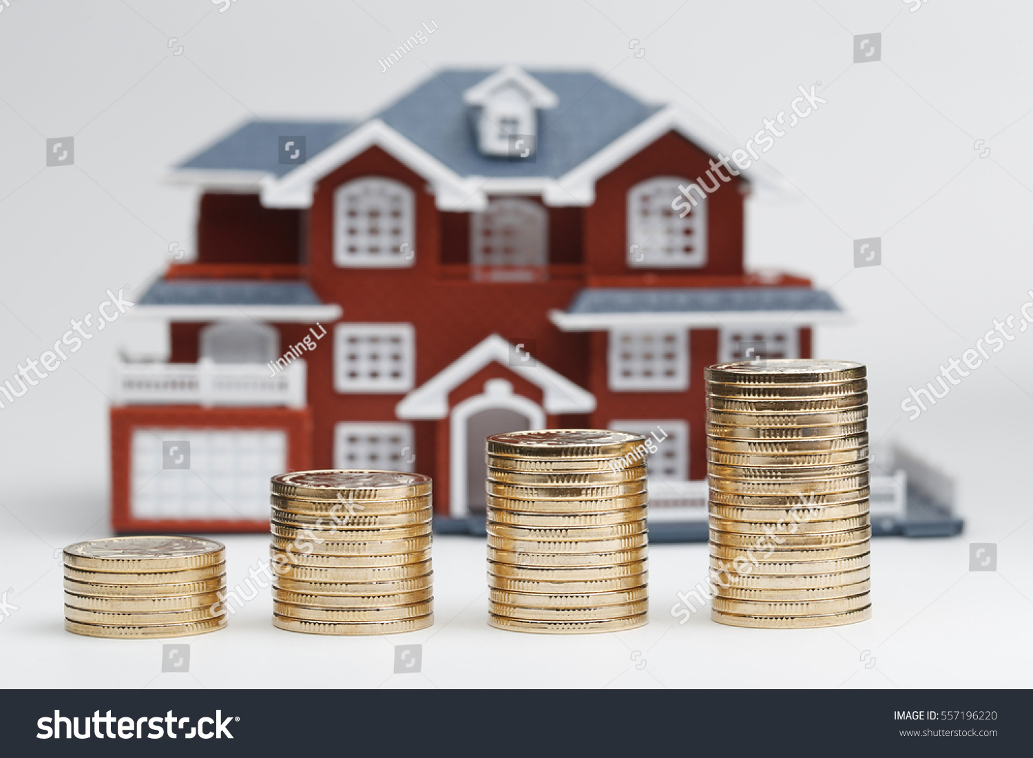 RMB coins stacked in front of the housing model (house prices, house buying, real estate, mortgage concept) #557196220