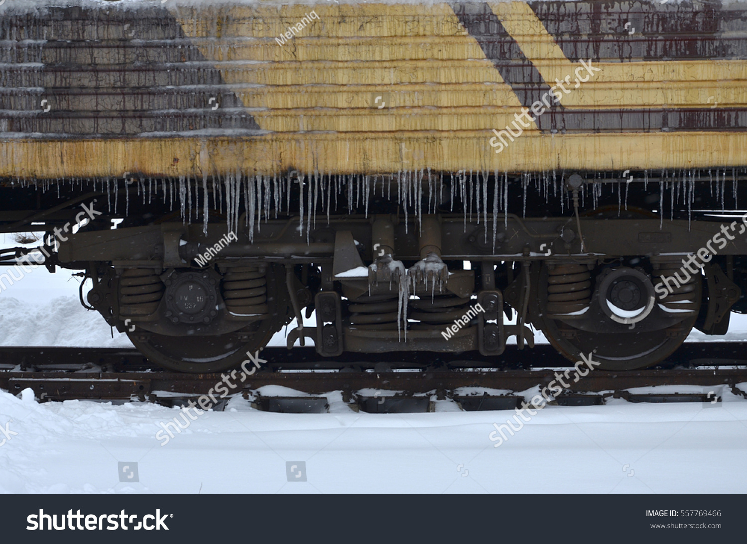 Detailed photo of a frozen car passenger train with icicles and ice on its surface. Railway in the cold winter season #557769466