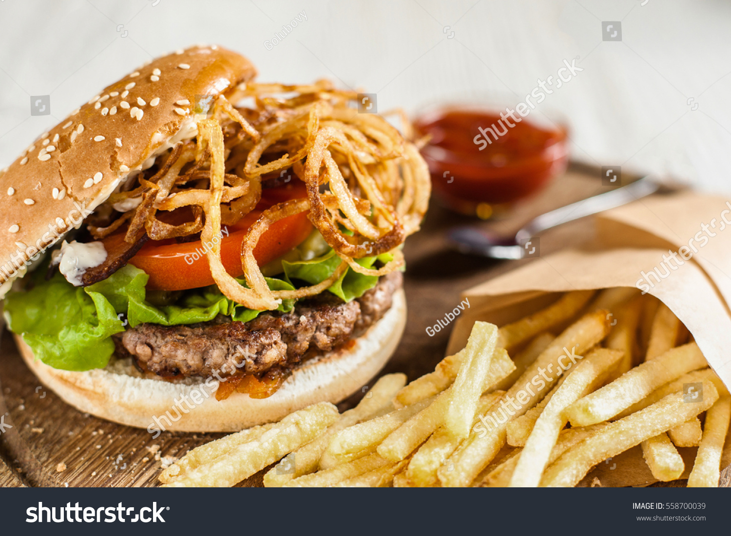 Restaurant serving of burger with fries and ketchup. Side view on catering platter with traditional american snack. Fast junk food, dining, fat eating concept #558700039