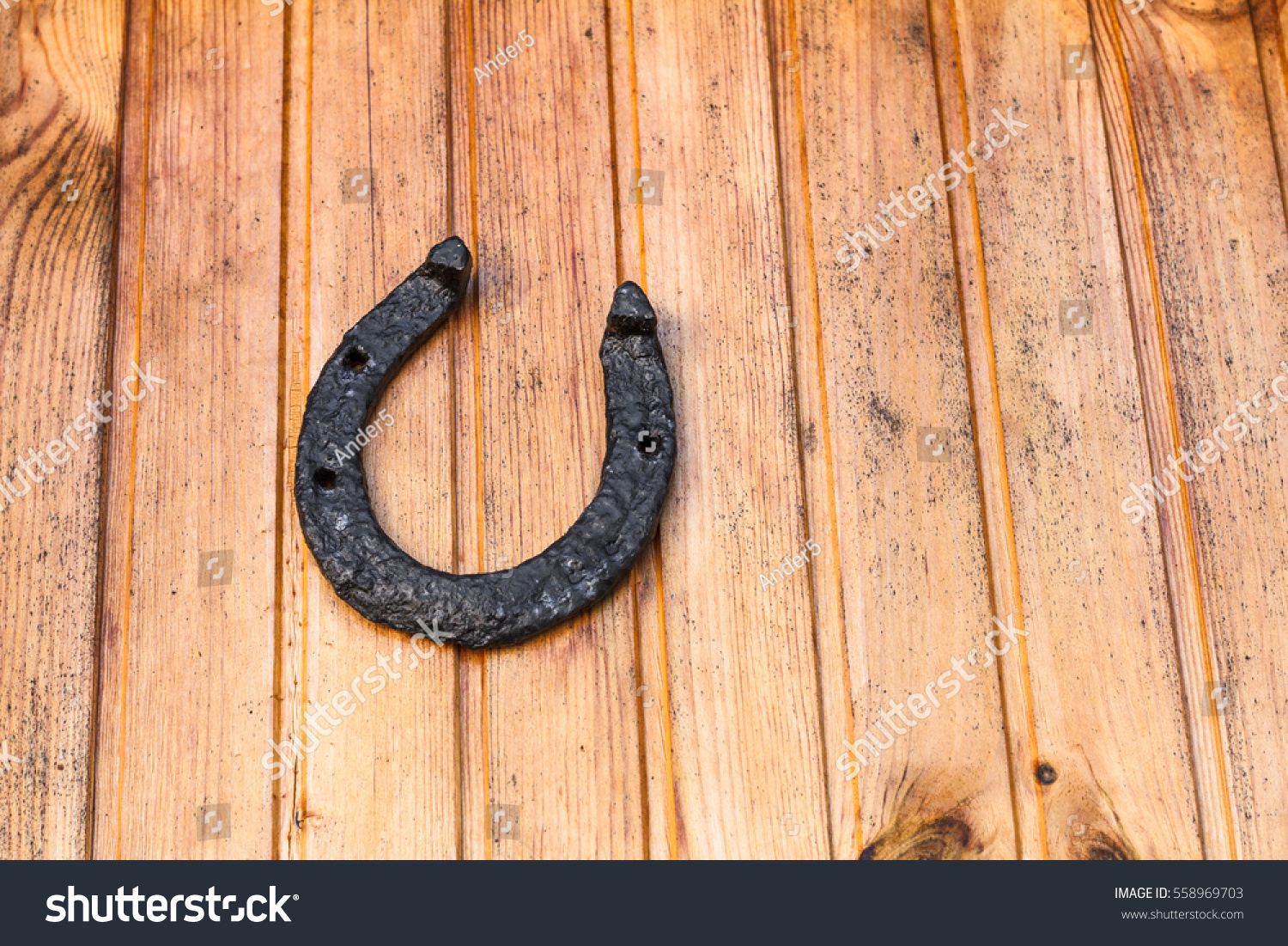 Old good luck horseshoe in black color nailed to wooden facing.
The horseshoe is probably one of the most well-known good luck and protective symbols of the Western world. #558969703