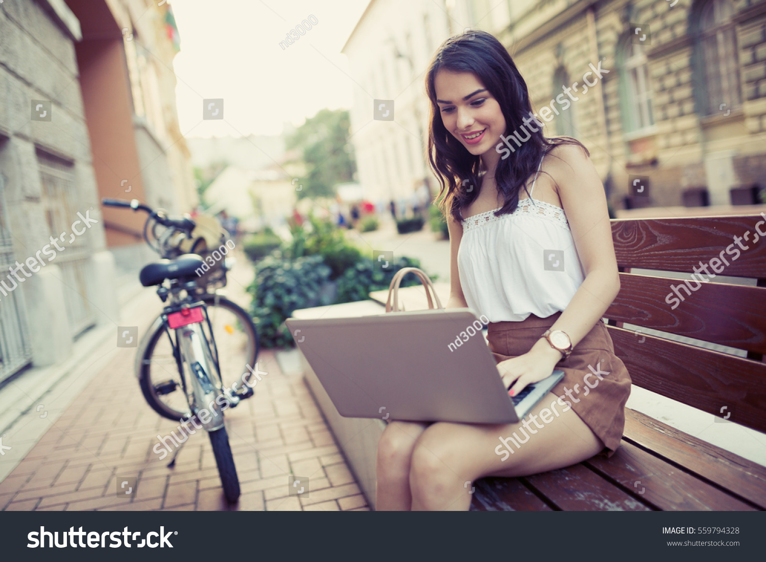 Female student using laptop in city #559794328