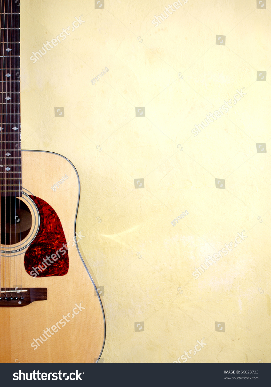 Color photo of an acoustic guitar near wall #56028733
