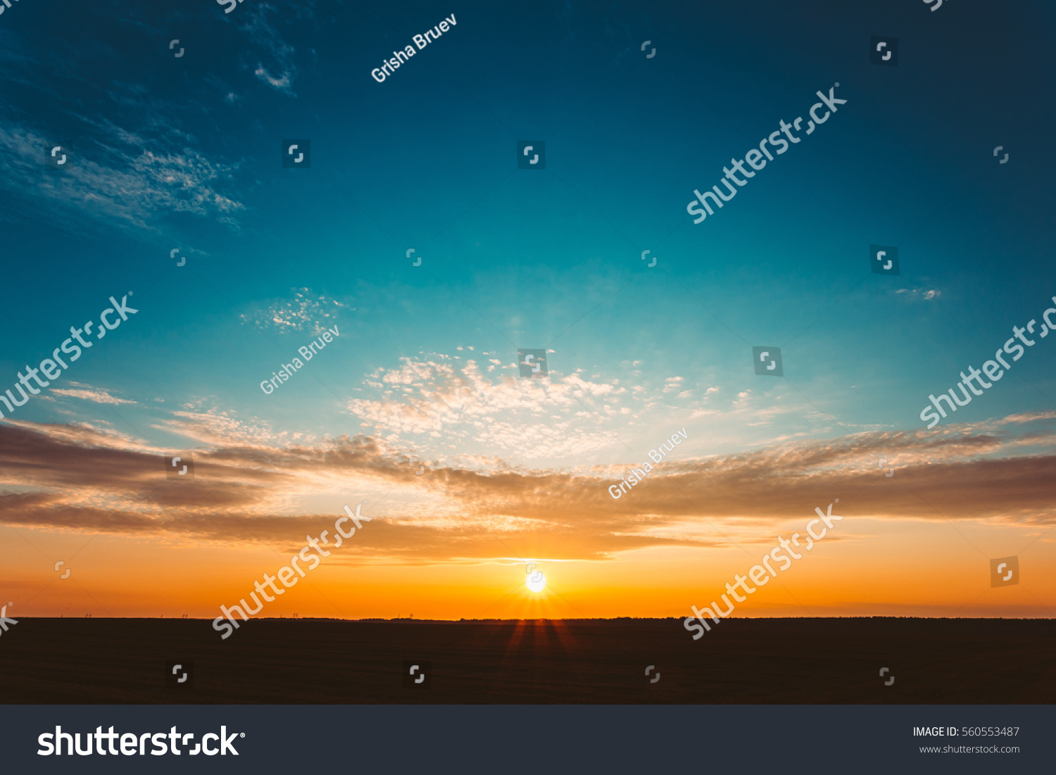 Natural Sunset Sunrise Over Field Or Meadow. Bright Dramatic Sky And Dark Ground. Countryside Landscape Under Scenic Colorful Sky At Sunset Dawn Sunrise. Sun Over Skyline, Horizon. Warm Colours. #560553487