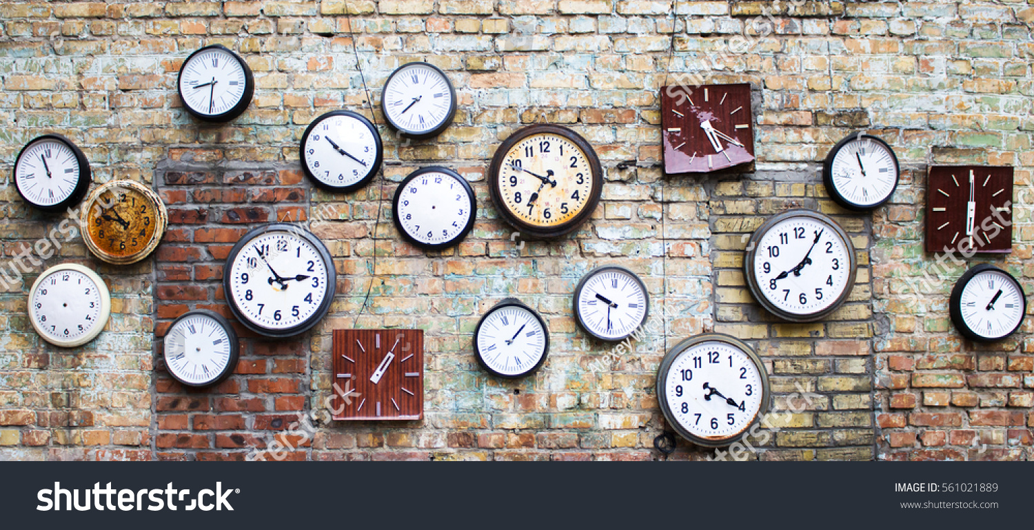Collection of vintage clock hanging on an old brick wall #561021889
