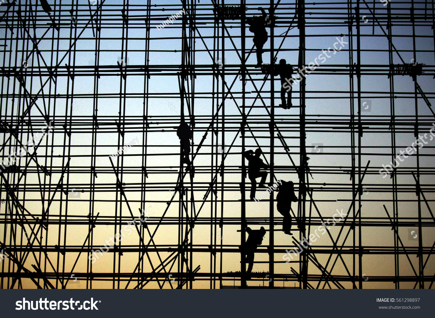 evening, the workers are climbing the silhouette of scaffolding in the high altitude, horizontal and vertical scaffolding formed a myriad of grid, industrial and modern urban construction background. #561298897