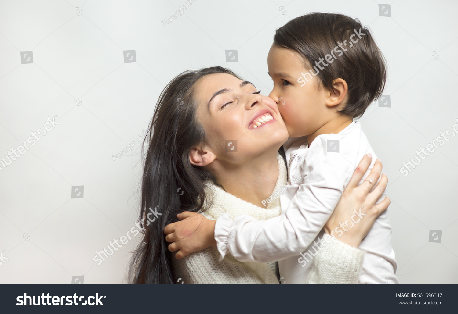 little girl  kissing her mother #561596347