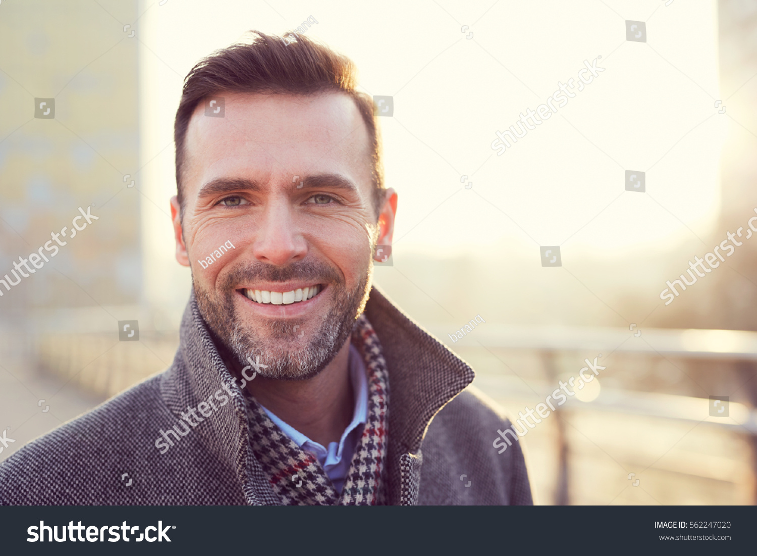 Portrait of happy man smiling outdoors during cold winter day #562247020