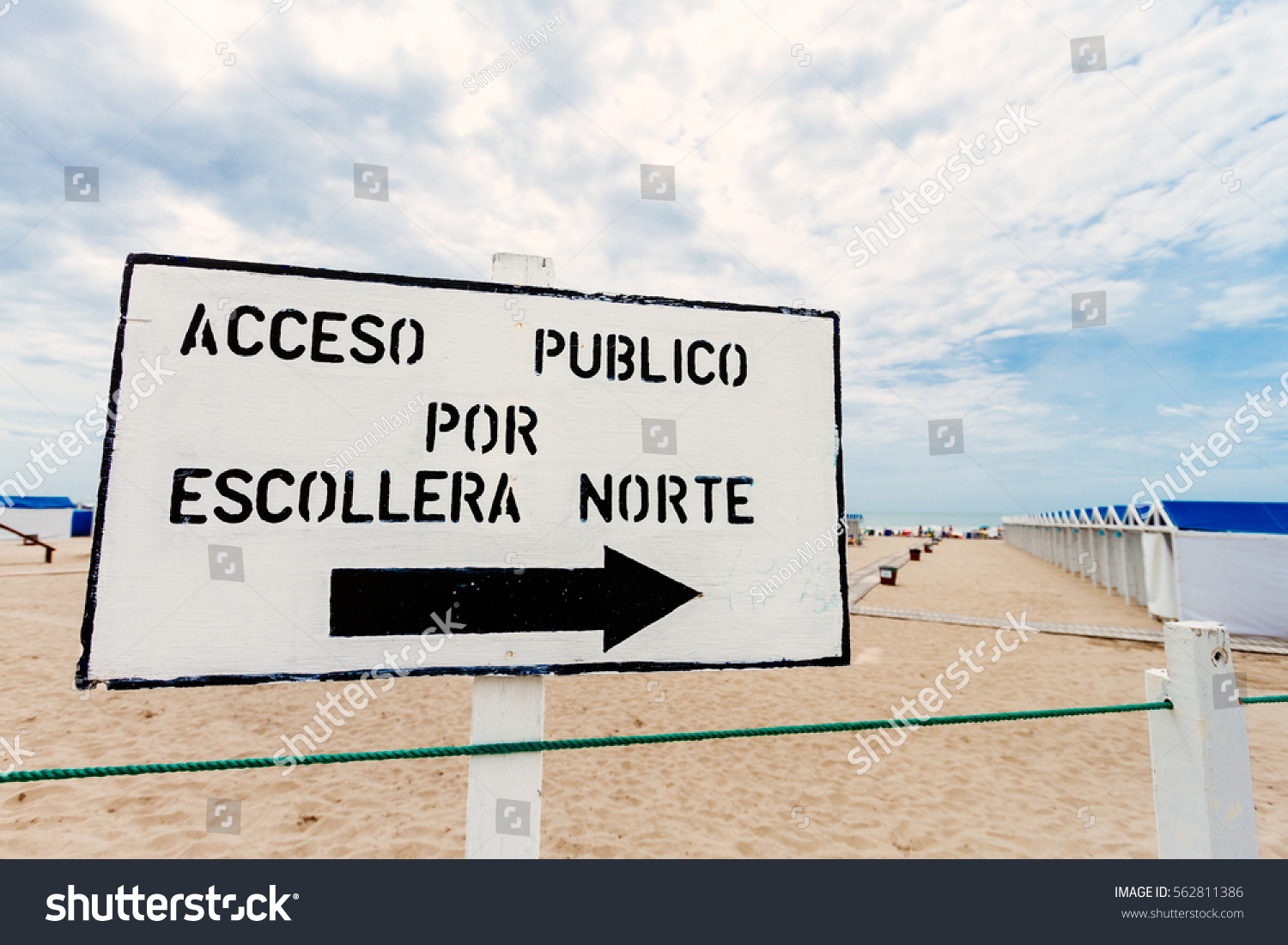 Sign inscribed "Public Access northern breakwater" written in Spanish at the entrance of a beach resort #562811386