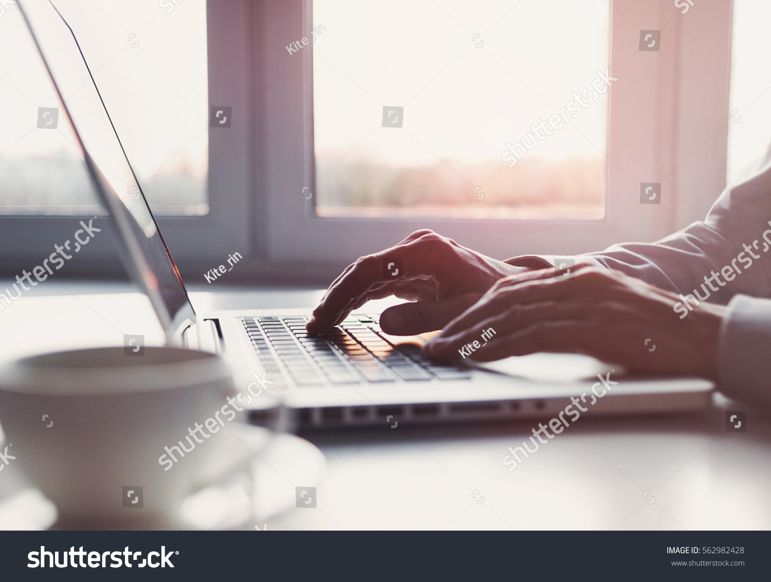Business man using laptop computer at home. Male hand typing on laptop keyboard in office. Businessman, student, work from home, distance education, online learning, studying concept #562982428