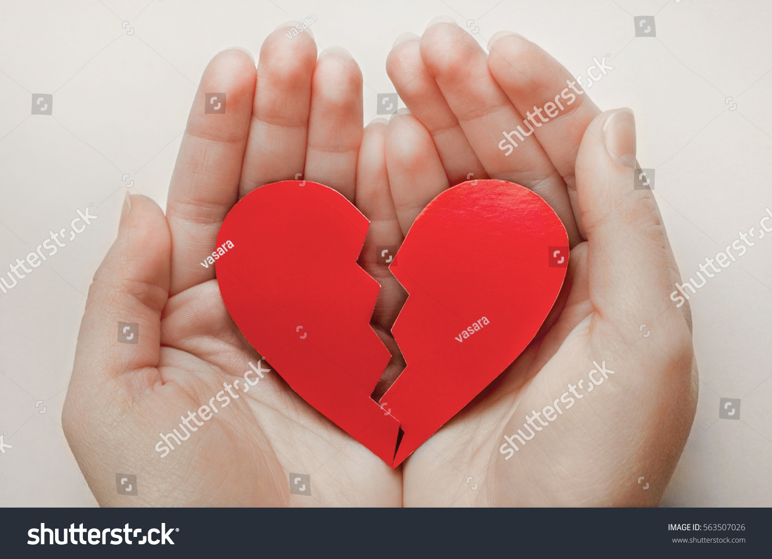 Close up of paper broken heart on white wooden background #563507026
