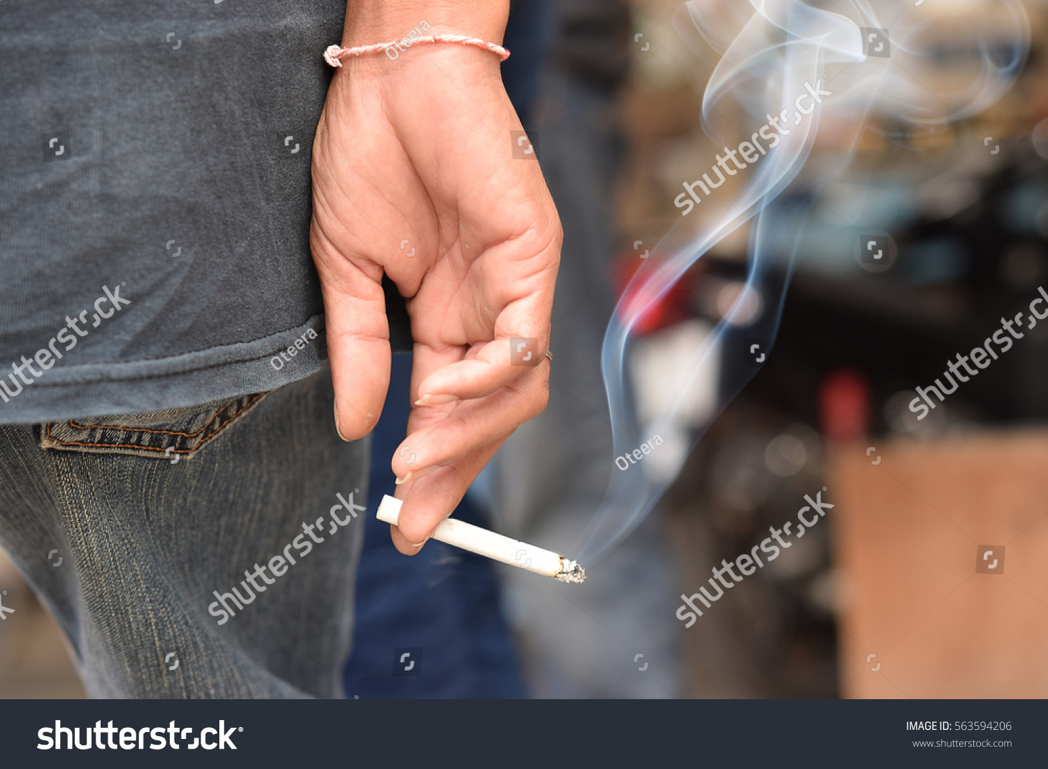 Image of cigarette in man hand with smoke. #563594206