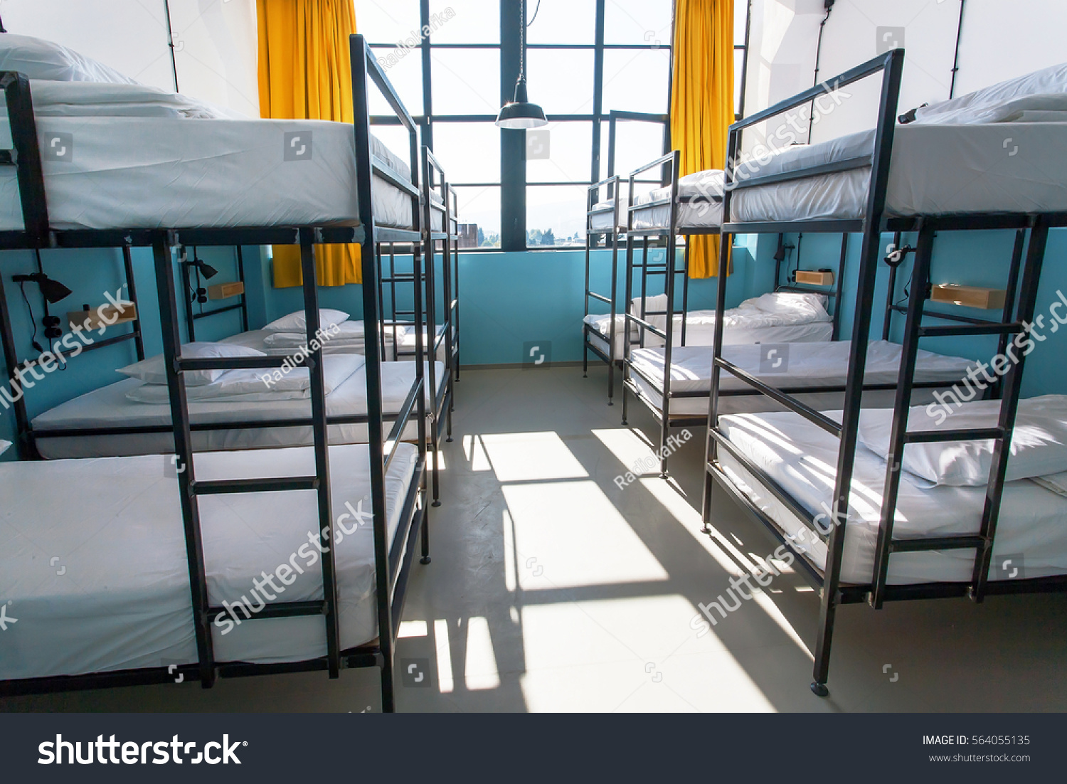 Morning inside the hostel bedroom with clean white beds for students and lonely young tourists #564055135
