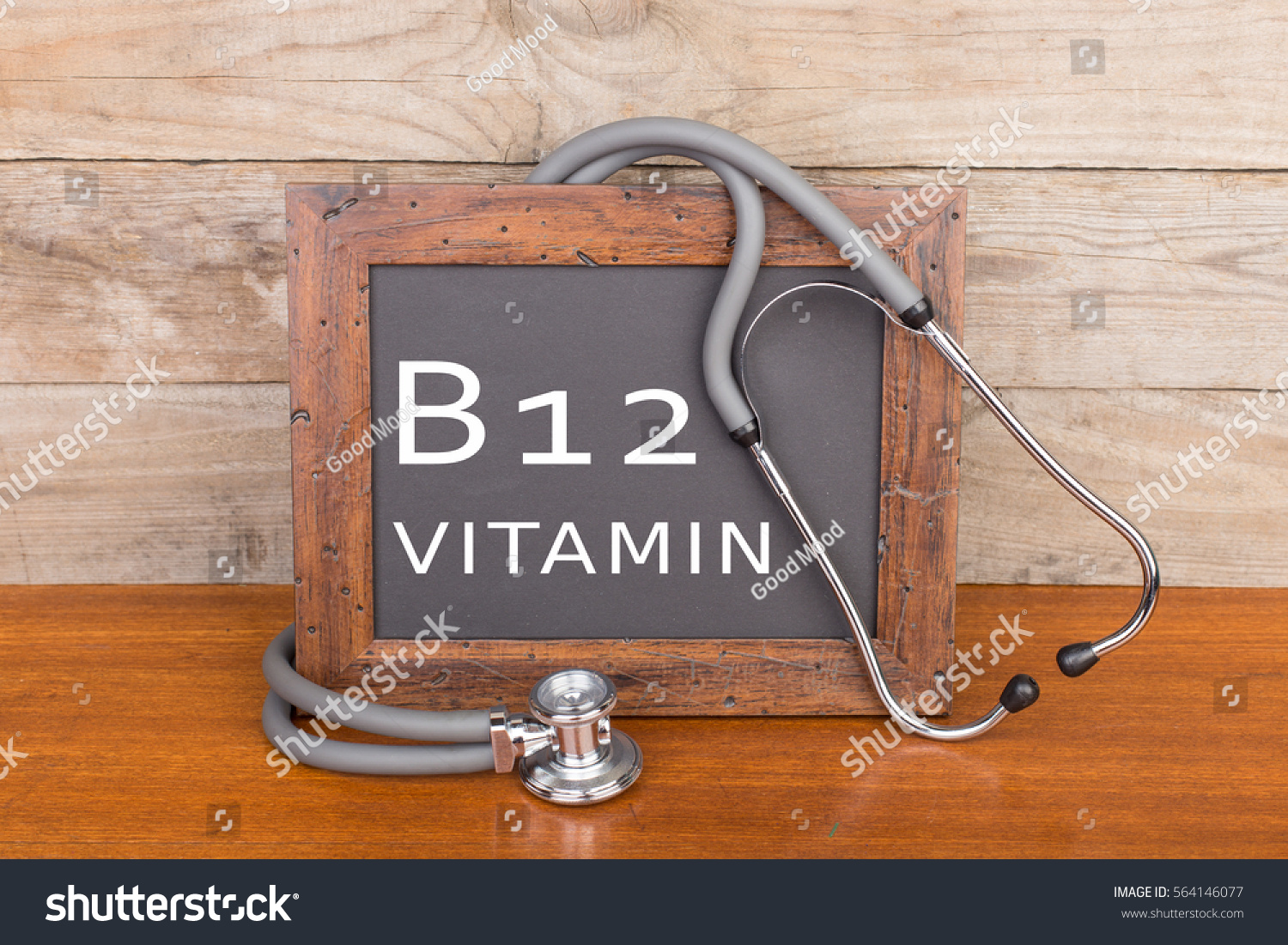 Medical concept - stethoscope and blackboard with text "Vitamin B12" on wooden background #564146077