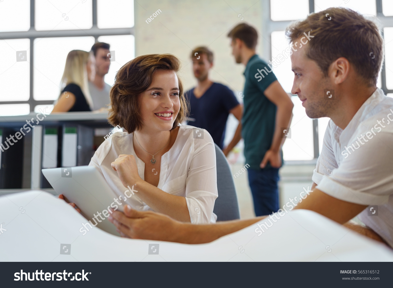 Male and female colleagues discuss business while working on laptop at morning meeting #565316512