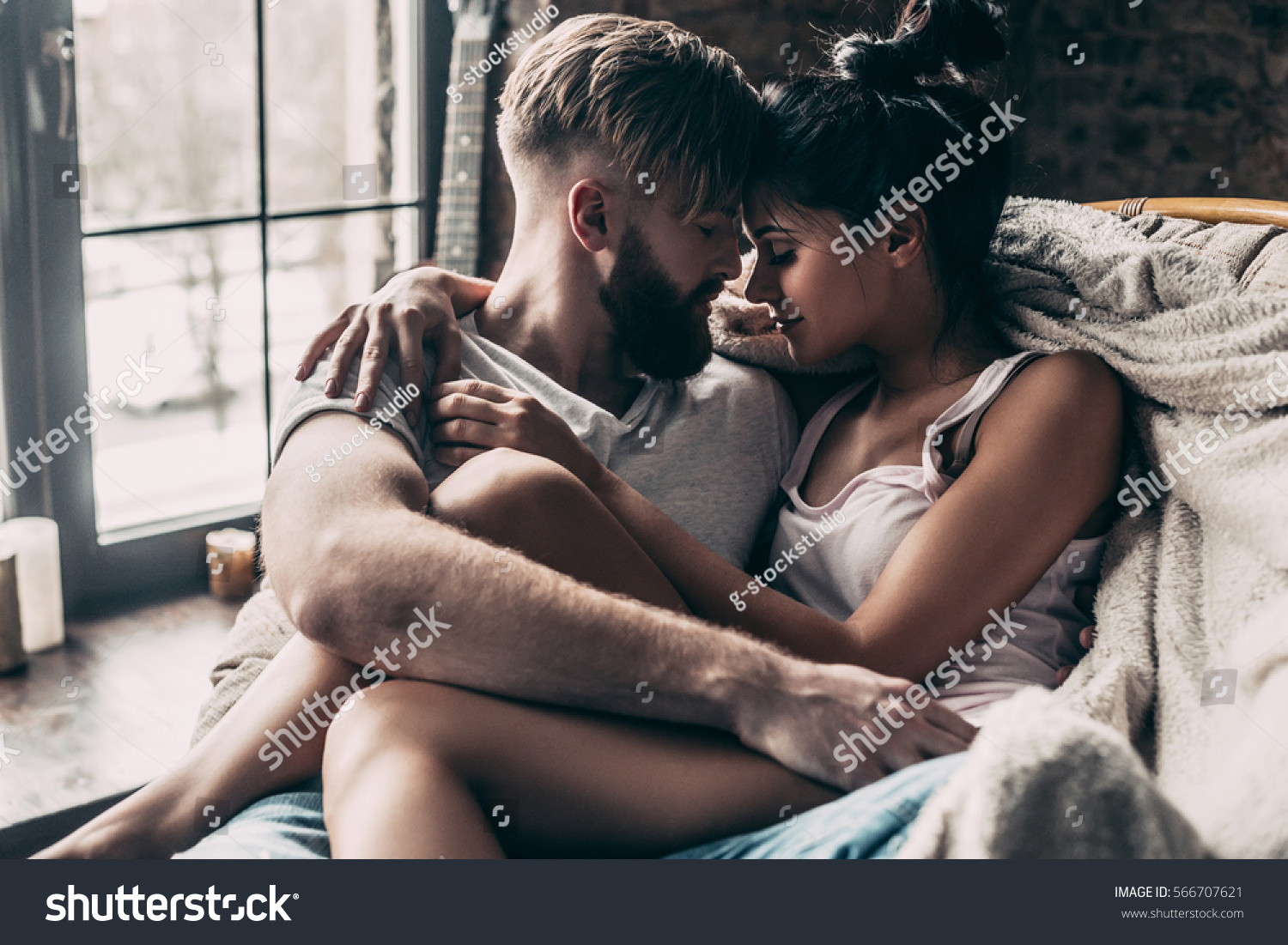 Love is in the air. Young couple sitting face to face and keeping eyes closed while spending time at home together #566707621