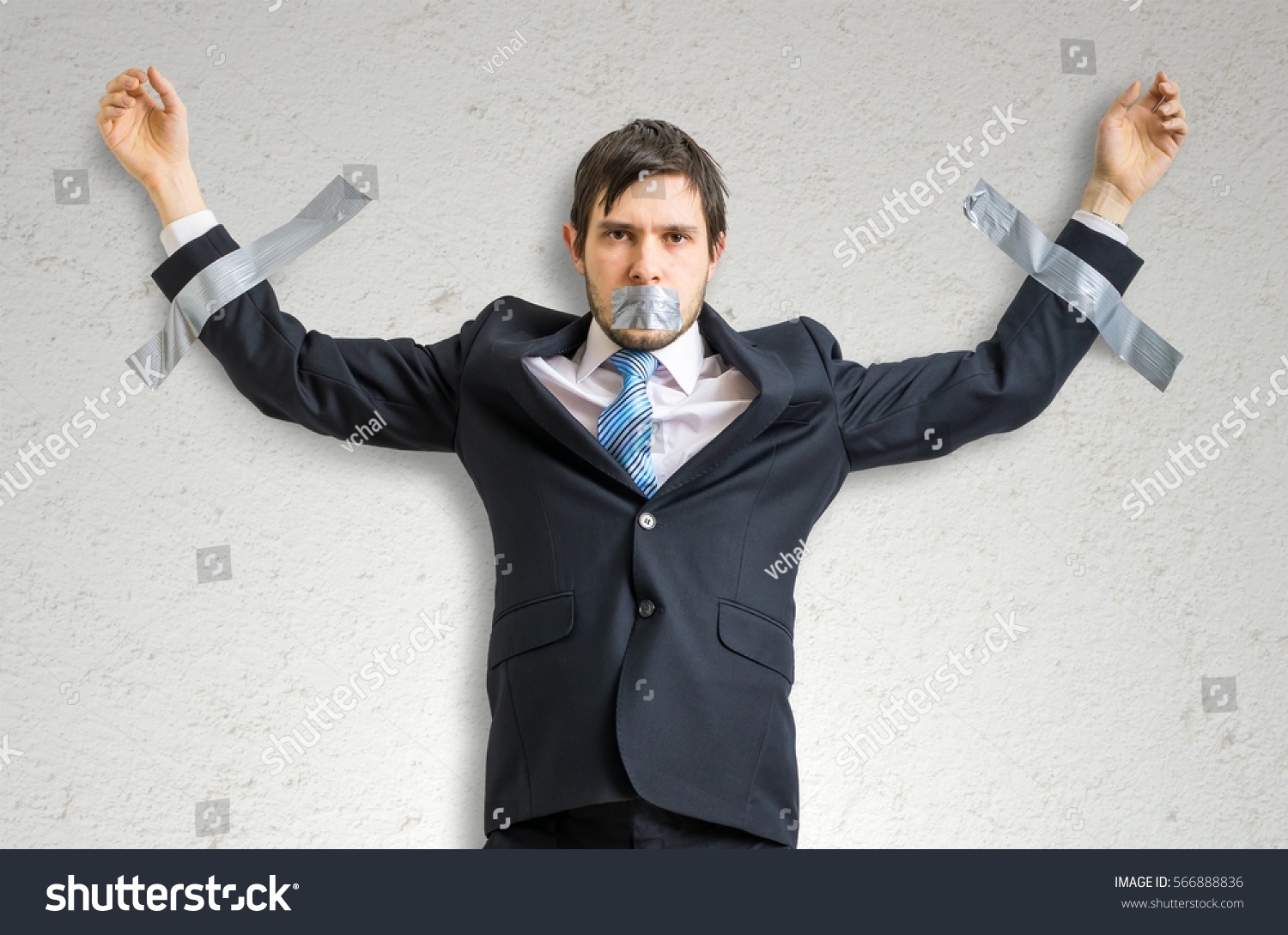 Businessman in suit is taped to the wall with adhesive tape. #566888836