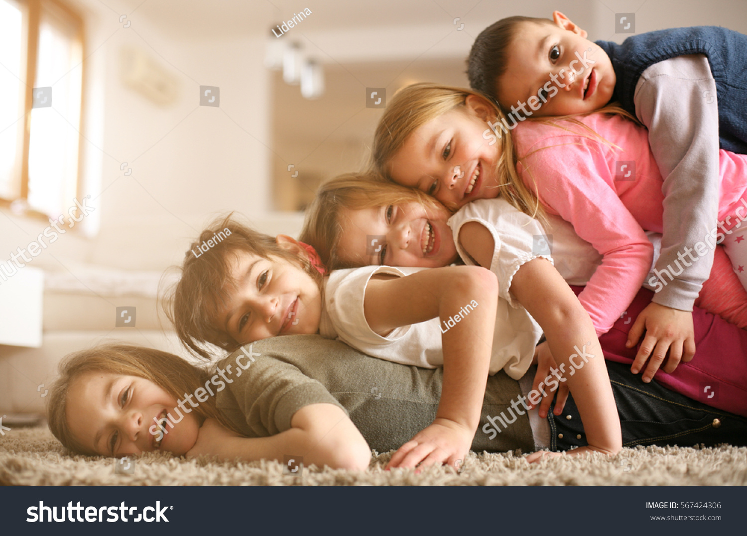 Large group of children lying at floor and having fun. Looking at camera. #567424306