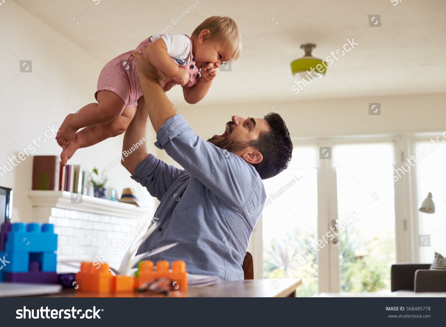 Father Sits At Table And Plays With Baby Son At Home #568485778