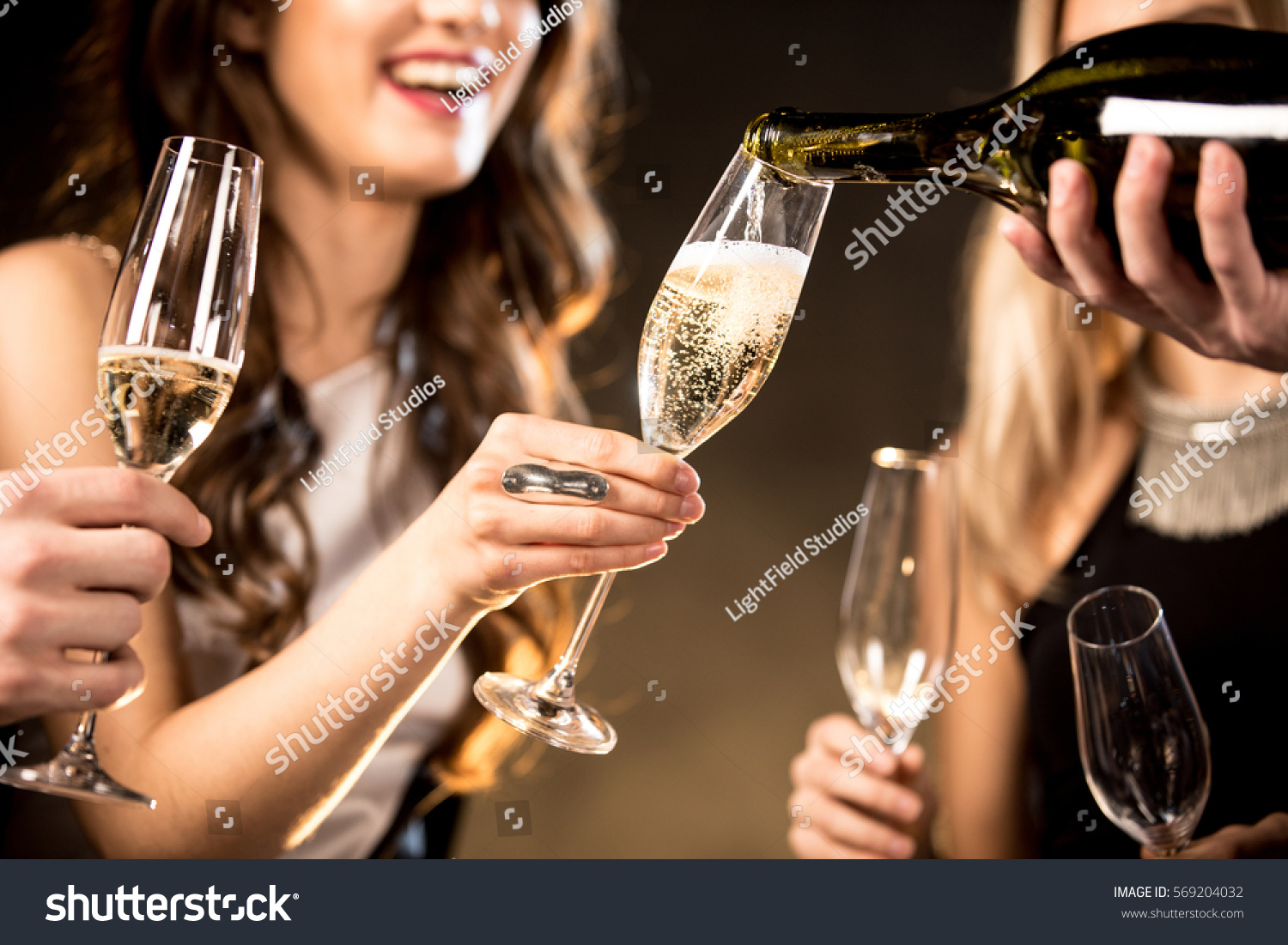 Partial view of happy young friends drinking champagne  #569204032