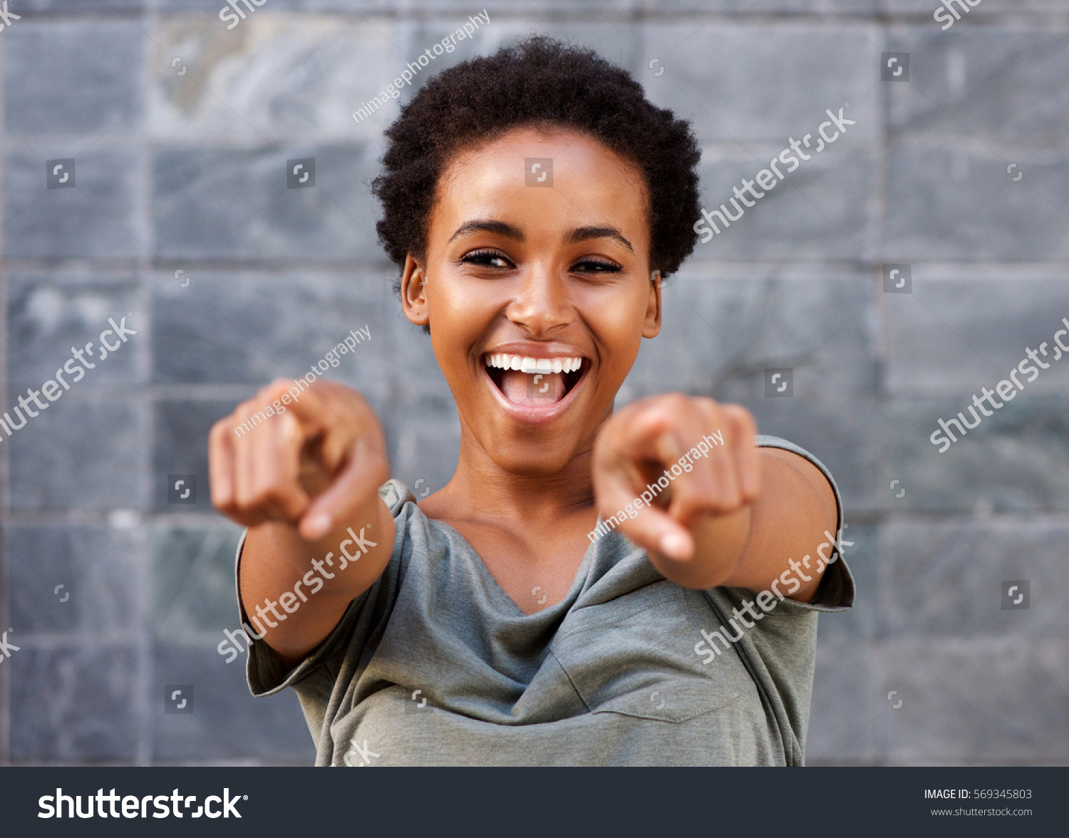 Portrait of attractive happy young black woman pointing fingers #569345803