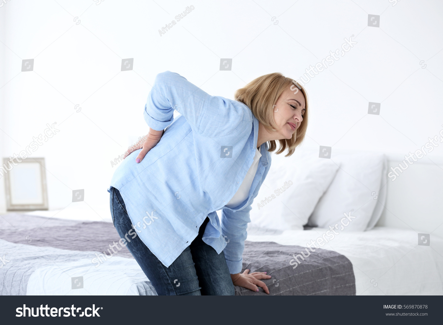 Senior woman suffering from backache at home #569870878