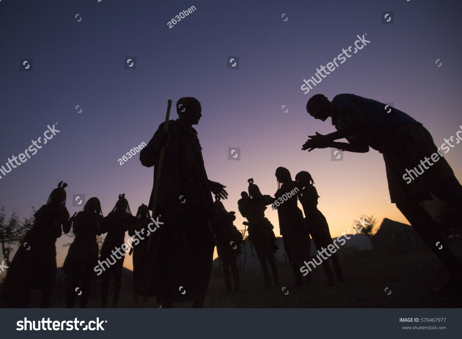 EPUPA, NAMIBIA - CIRCA AUGUST 2016 - Himba villagers gather at dusk to perform a trditional dance. This dance allows visitor to see their culture while providing an income. #570467977