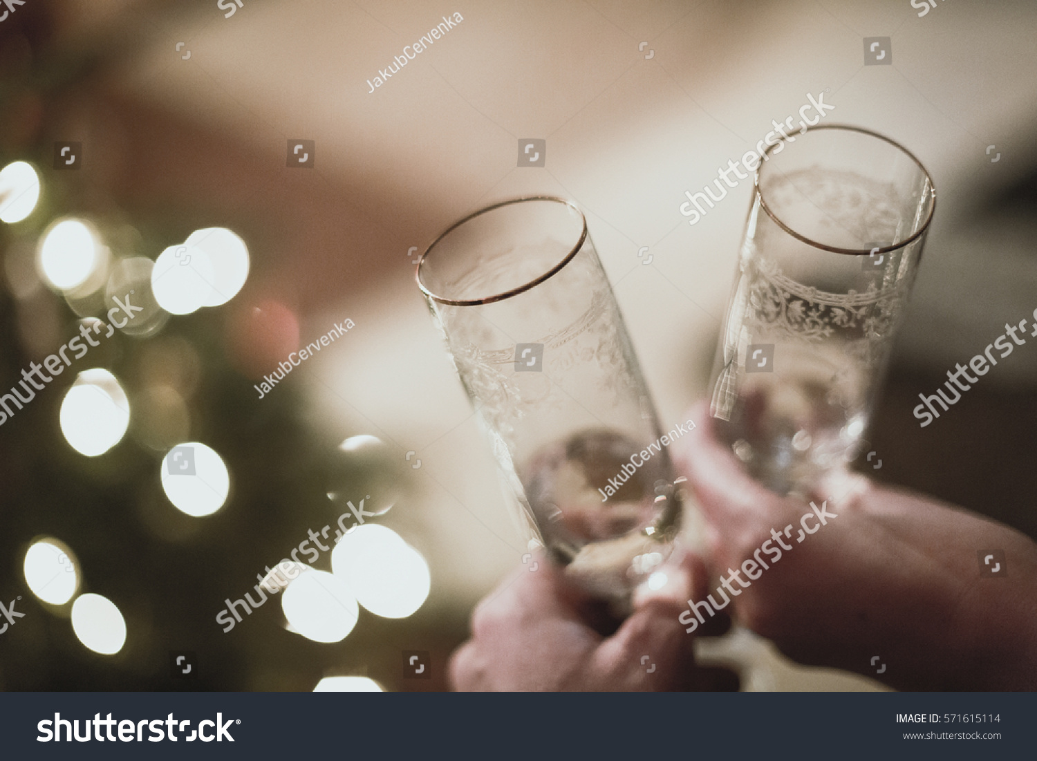 happy new year toast with a christmas tree lights in background #571615114