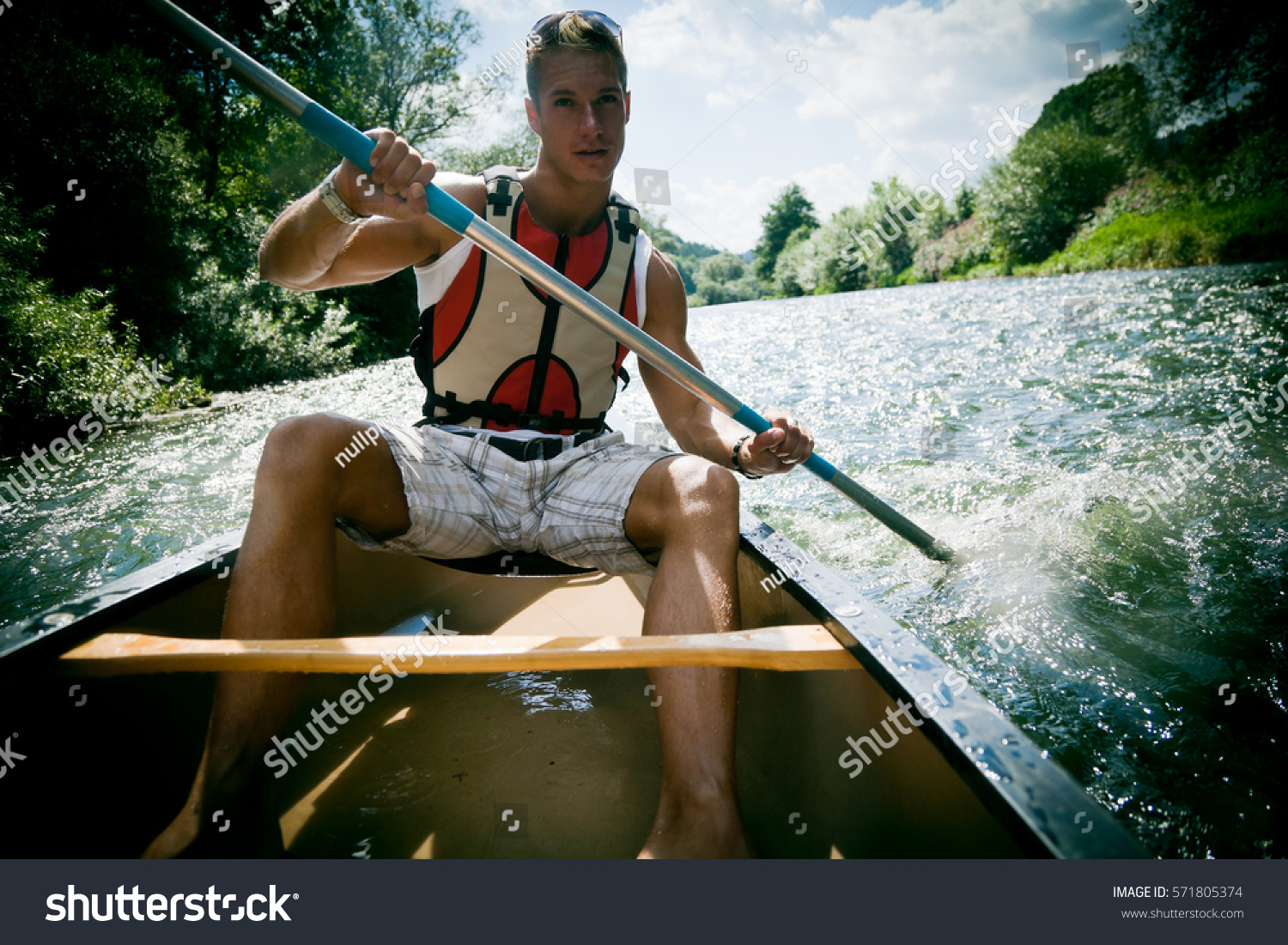 Young Man Canoeing #571805374