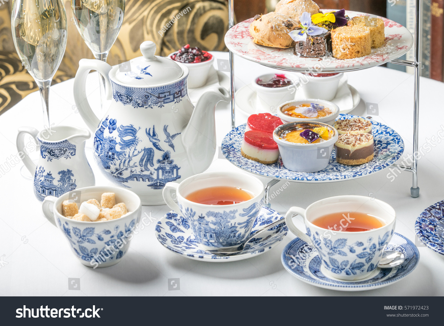 old school style tea at five afternoon service sandwich set cake sweet traditional table hotel cheesecake sugar pot blue china cup  #571972423