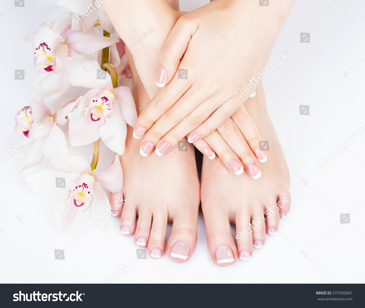 Closeup photo of a female feet at spa salon on pedicure and manicure procedure - Soft focus image #572592661